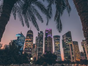 palm trees and skyscrapers in a city at night